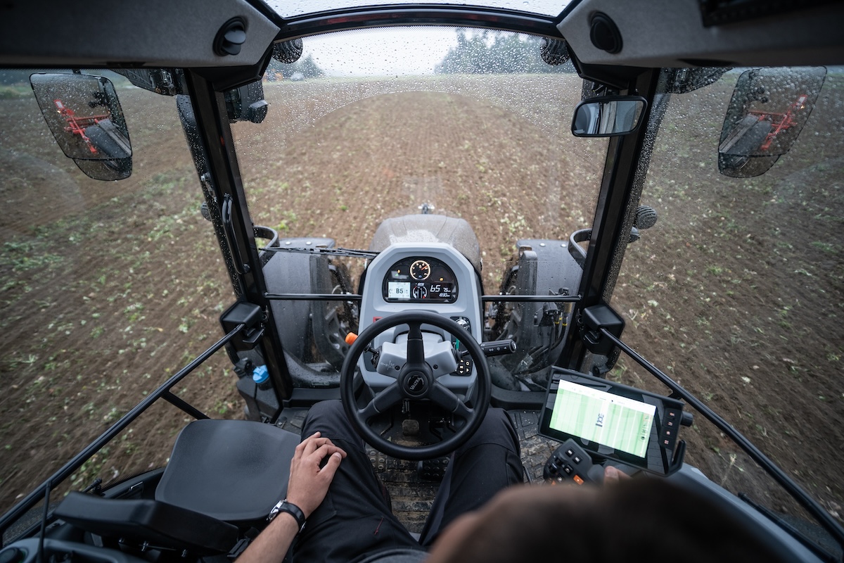 Il conducente gestisce le tecnologie di Smart Farming dei trattori Valtra Serie G con il bracciolo e lo schermo SmartTouch in cabina